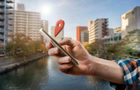 Mann mit Smartphone in der Hand und Darstellungen von lokalem Marketing